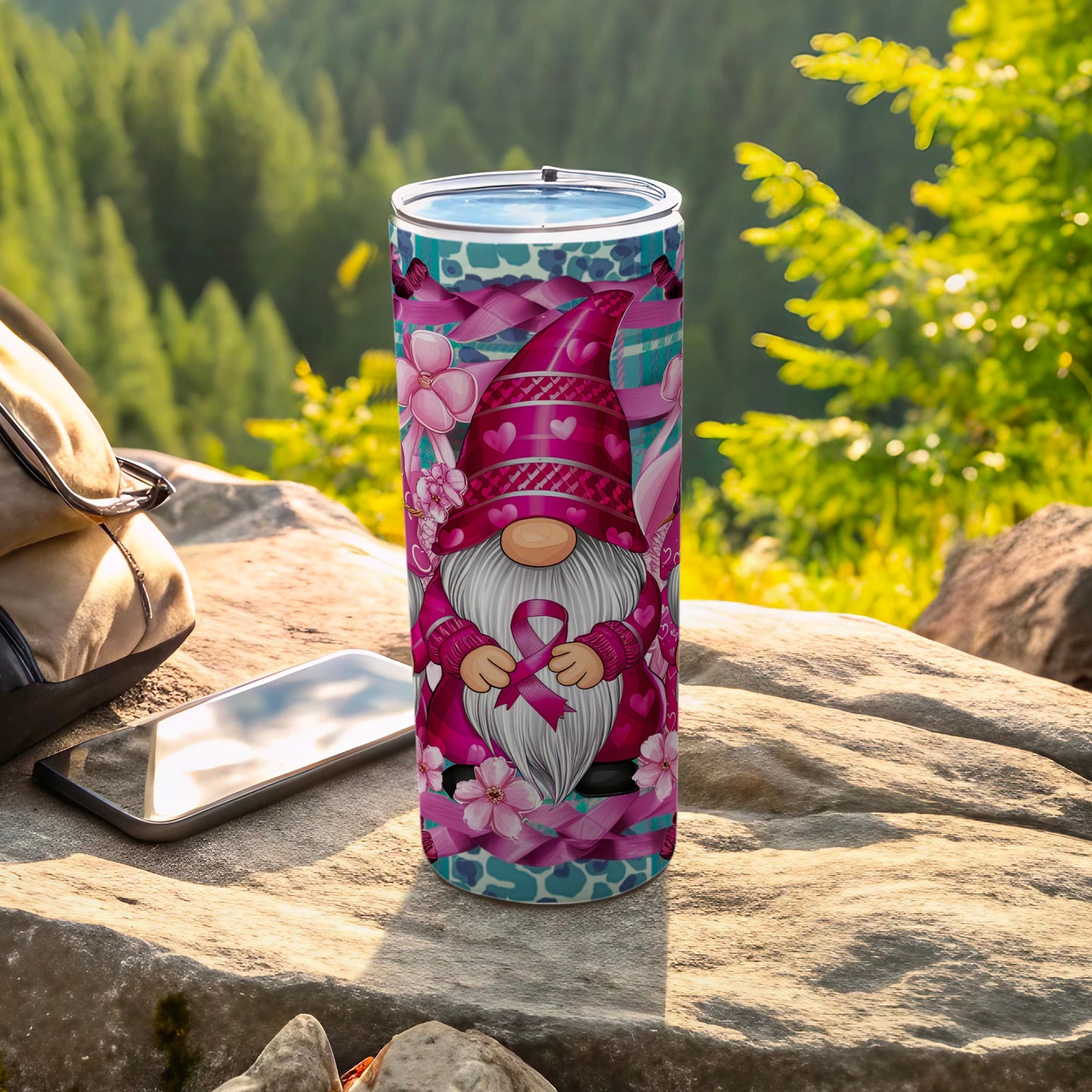 Pink gnome tumbler with breast cancer ribbon pattern on a rock.
