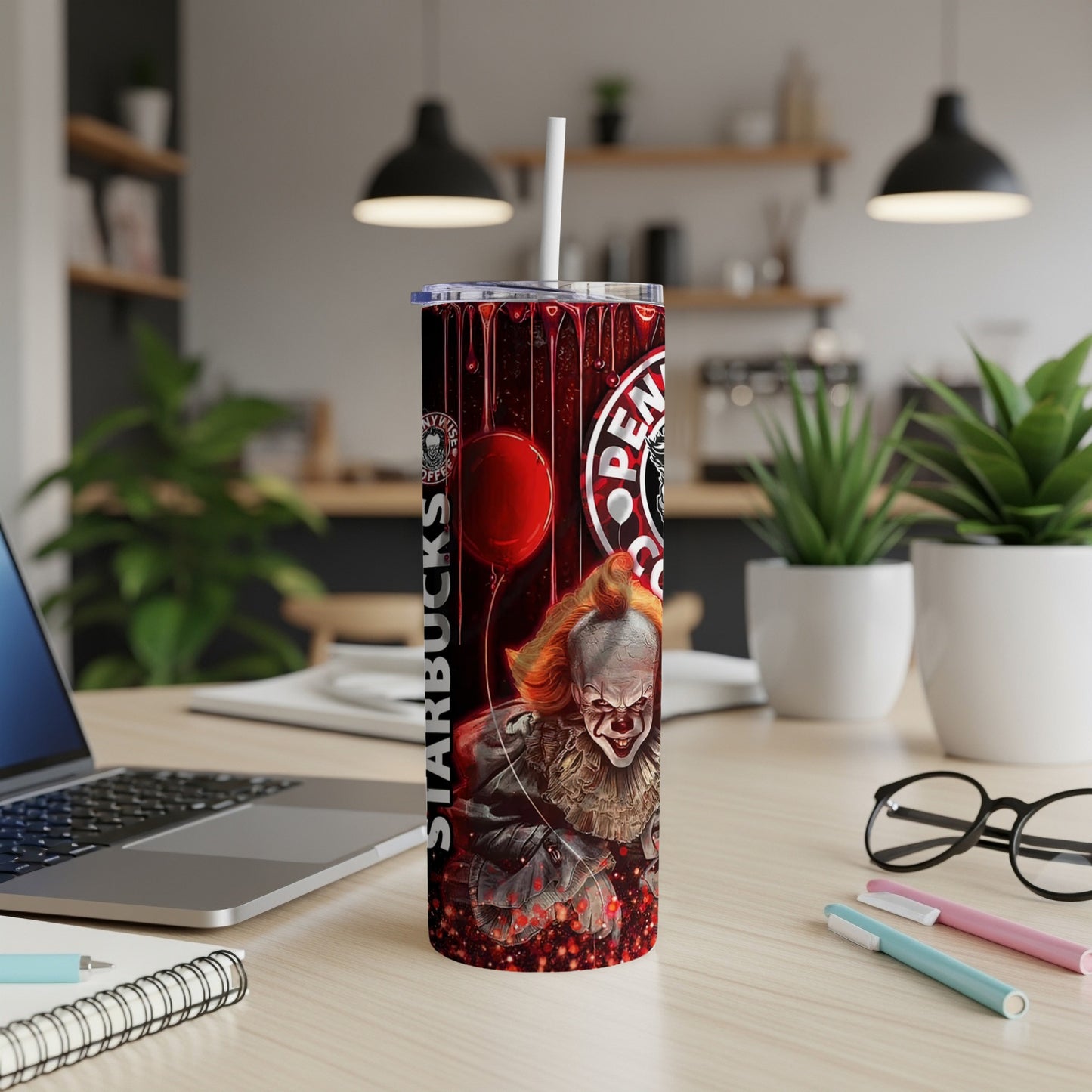 Tumbler with Pennywise, red balloon, and Starbucks logo, set on a desk.