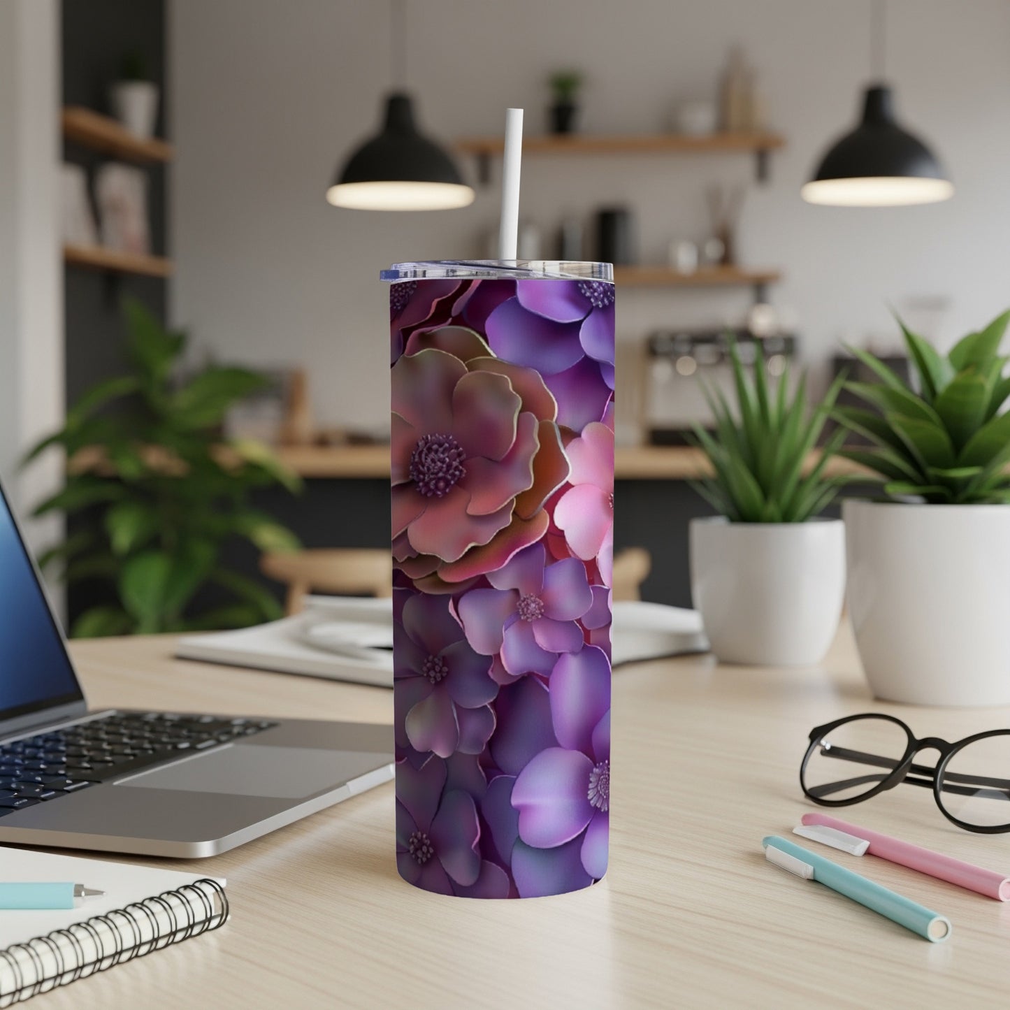 Purple floral tumbler with white lid and straw on desk.