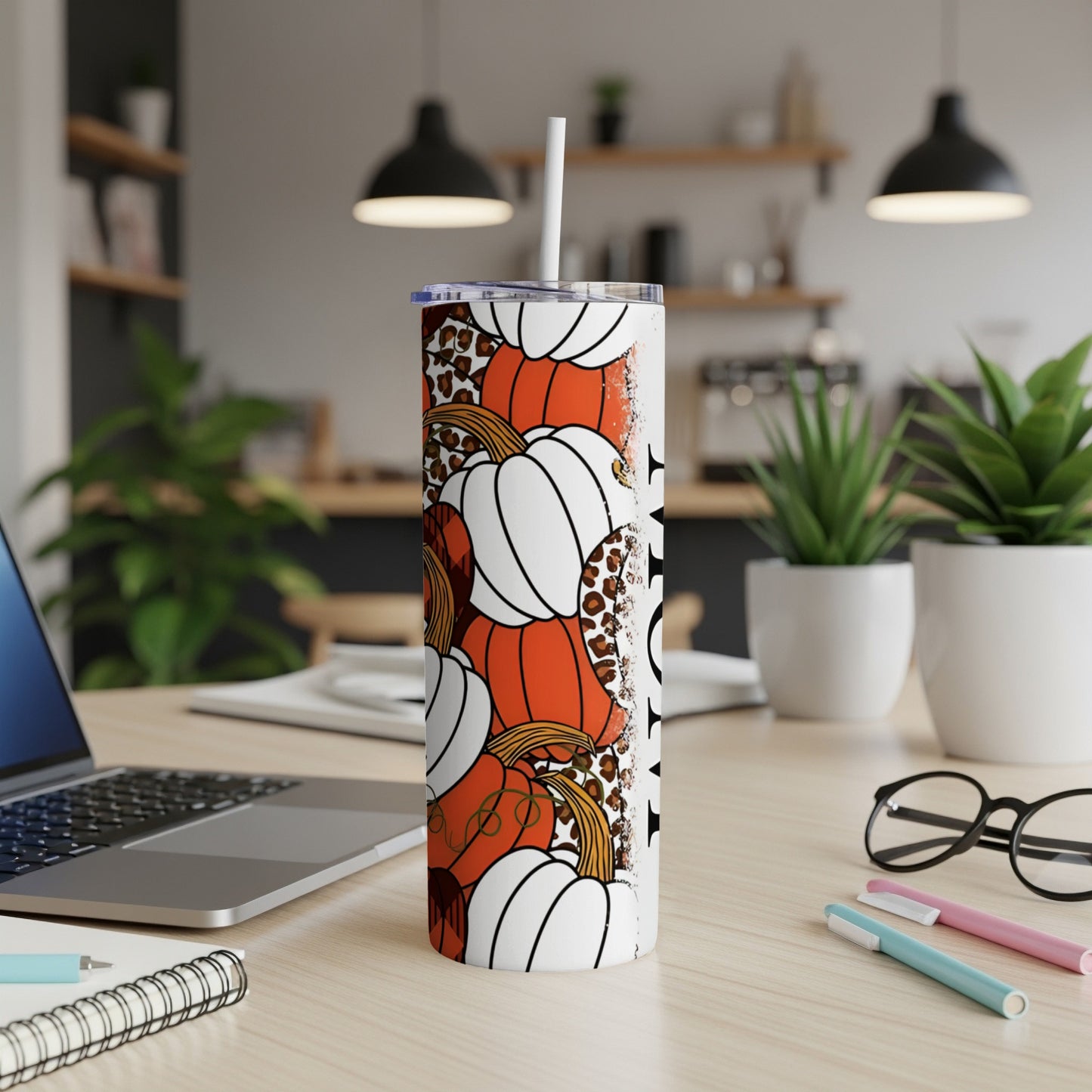 White tumbler with orange pumpkins and leopard print pattern.