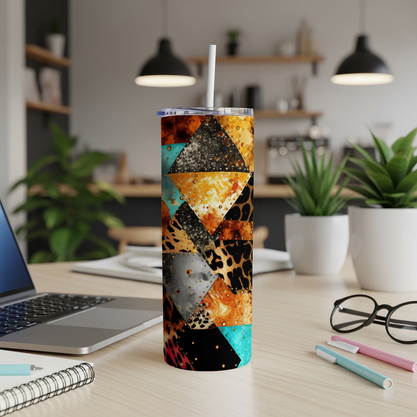 Geometric patchwork tumbler with leopard, cheetah, and gold accents on desk.