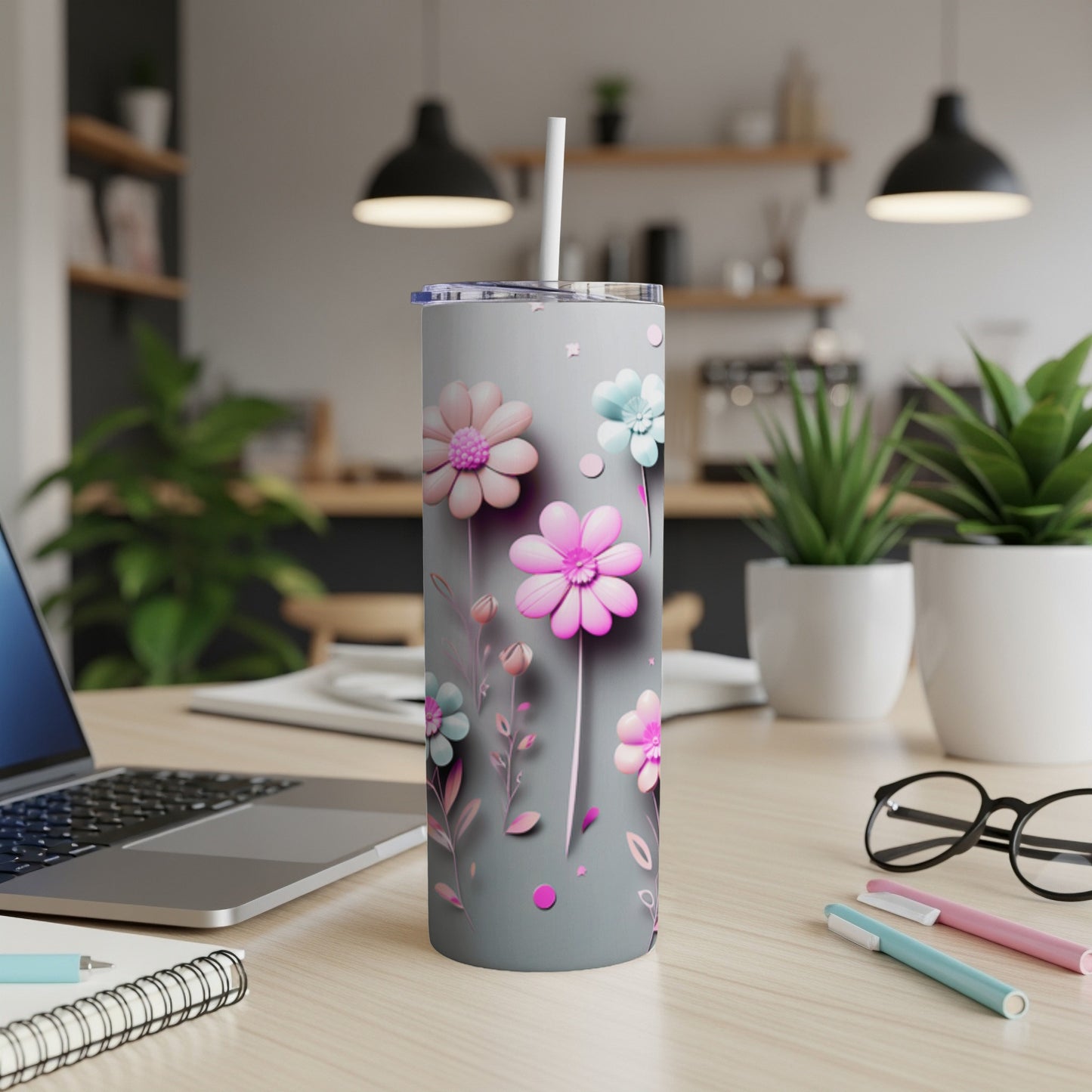 Gray tumbler with pink and blue floral design and straw.