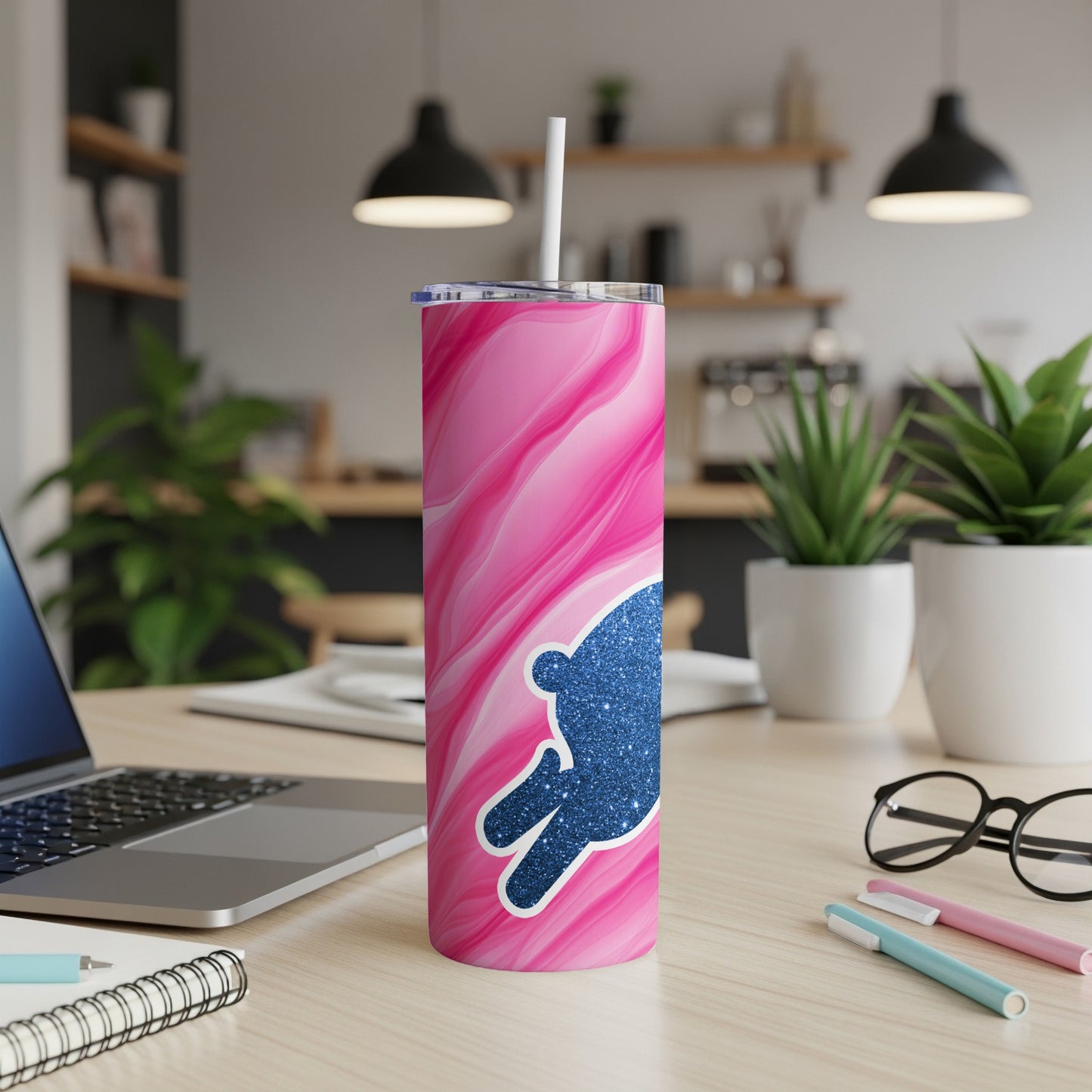 Pink marble tumbler with blue glitter bunny on a desk with laptop.