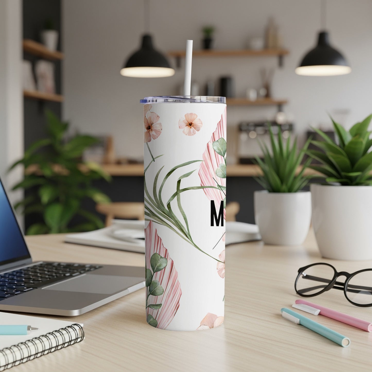 White skinny tumbler with pink floral and green leaf design and "M" initial.