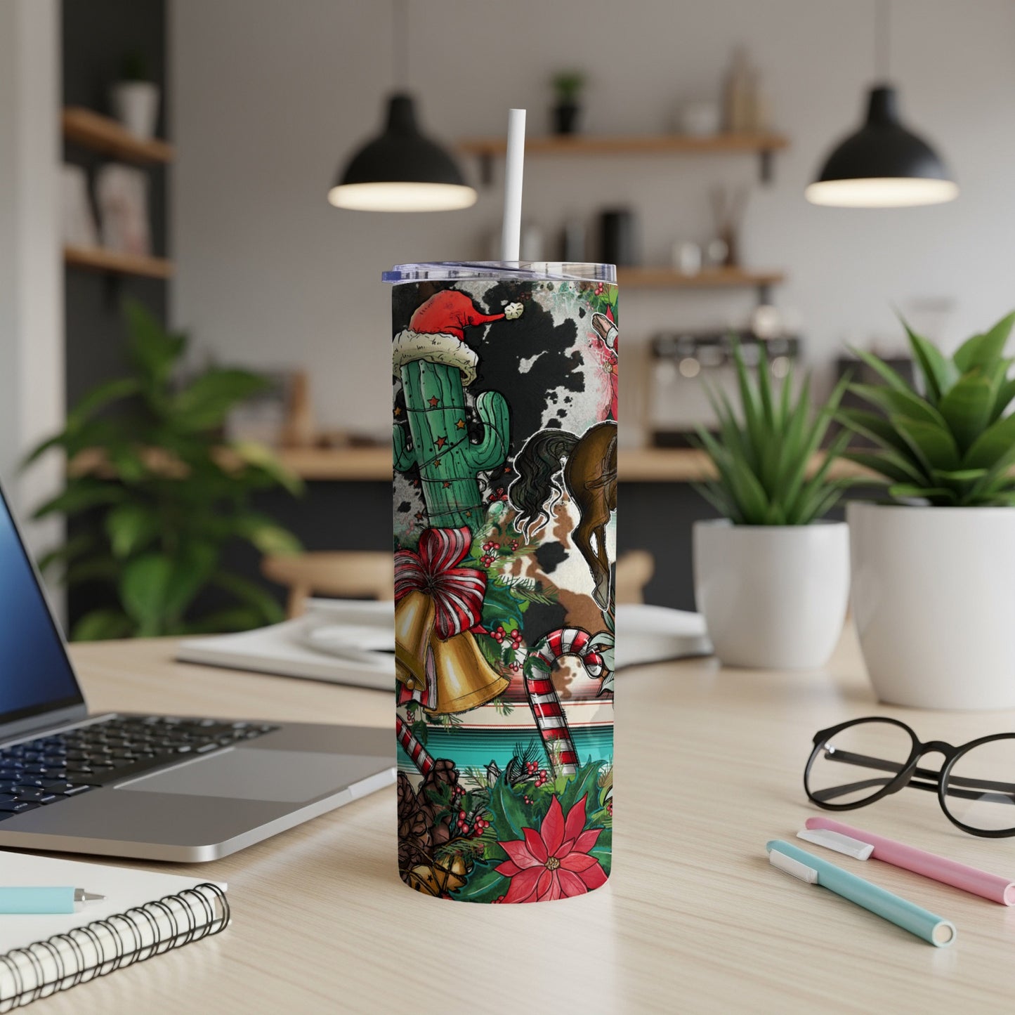 Christmas tumbler with cactus, cow print, bells, and poinsettias.