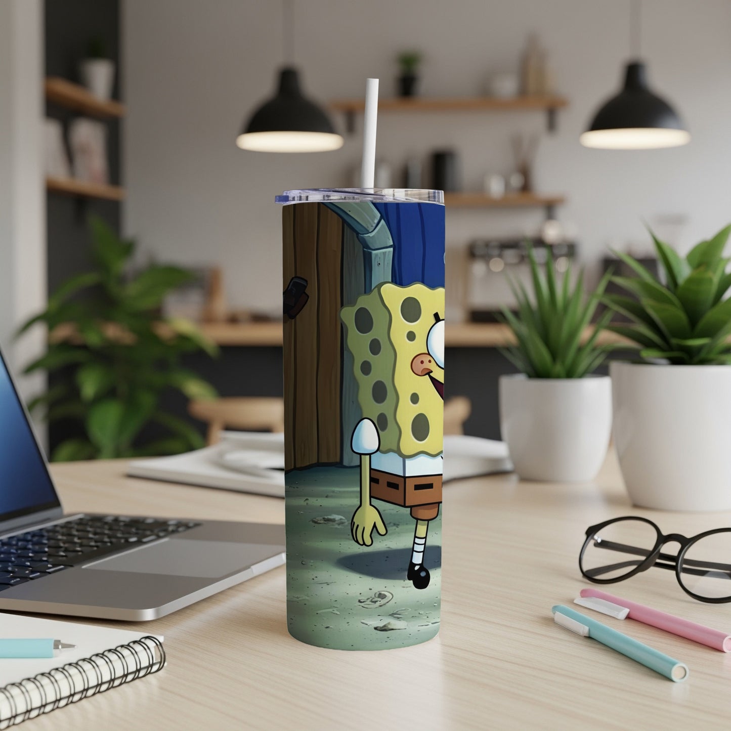 SpongeBob SquarePants standing next to his pineapple house on a wooden desk.
