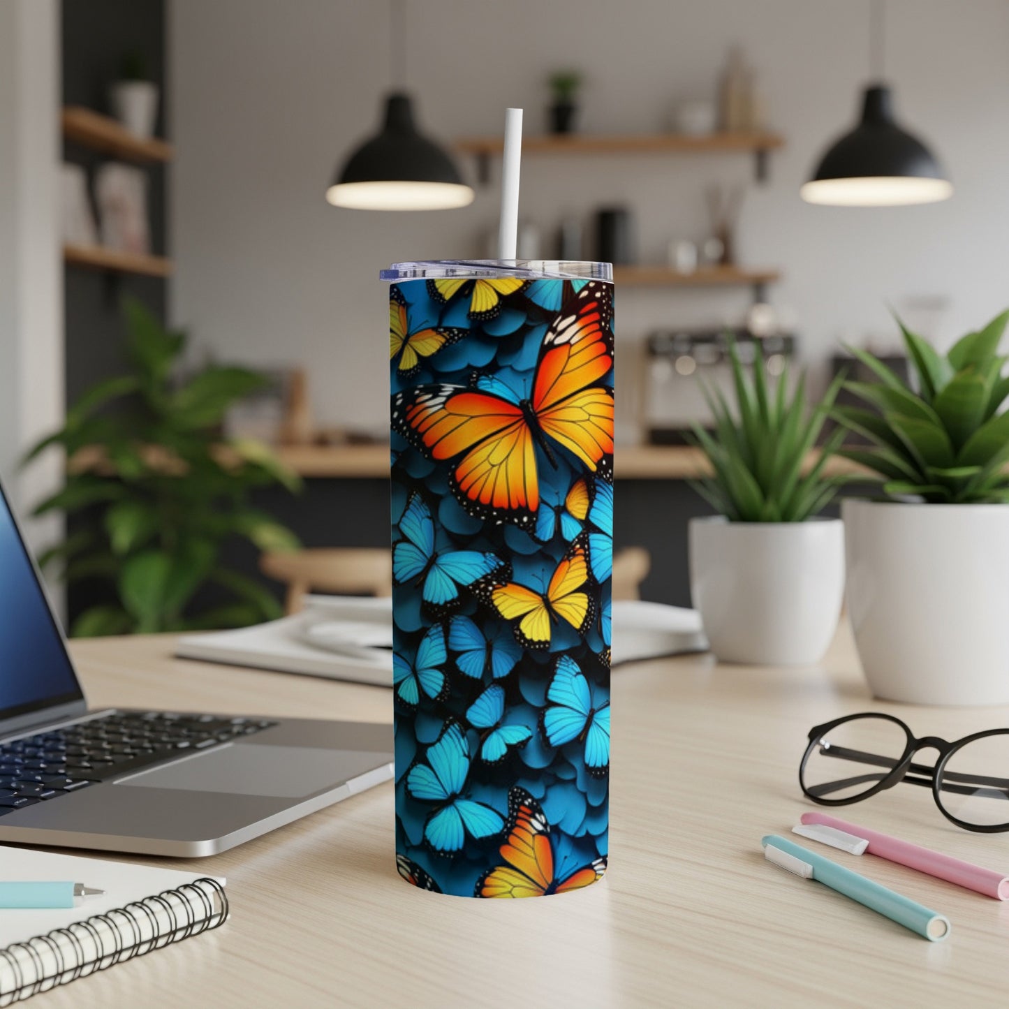 Tall tumbler with a colorful butterfly pattern and a white straw.