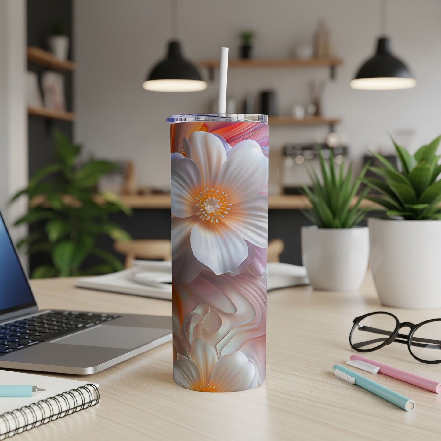 White floral pattern on a white tumbler with a straw on a desk.