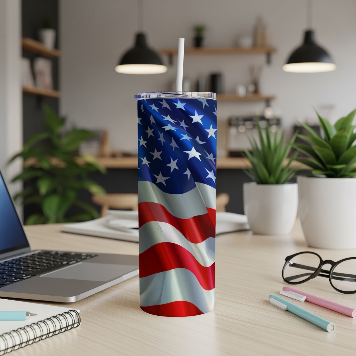 American flag tumbler with straw on a wooden desk.
