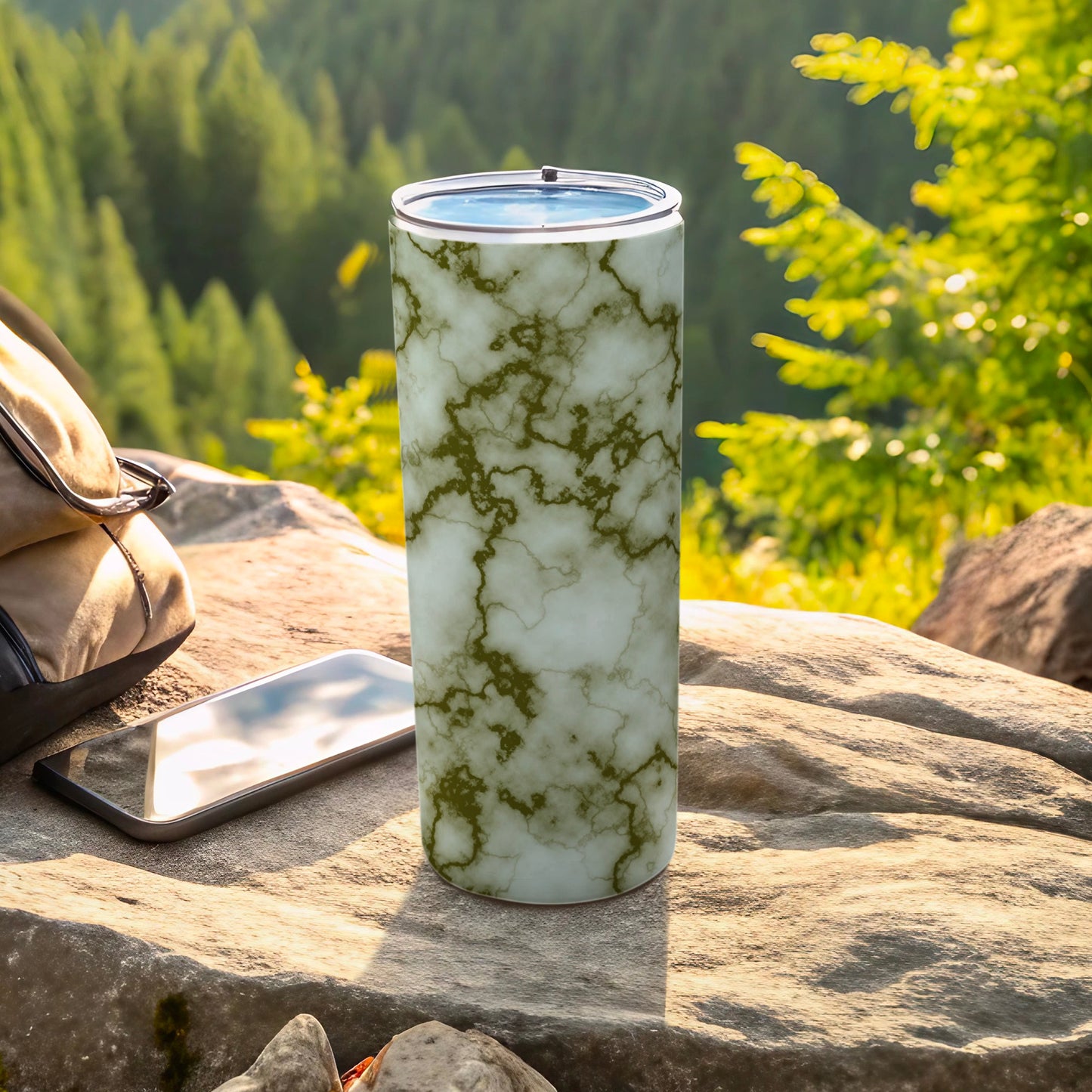 Marble pattern tumbler with phone and backpack outdoors.