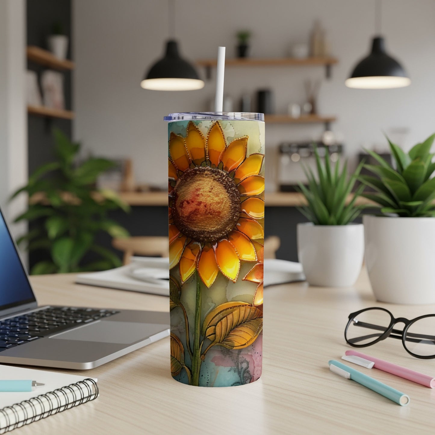 Tall tumbler with a watercolor sunflower design, on a desk.
