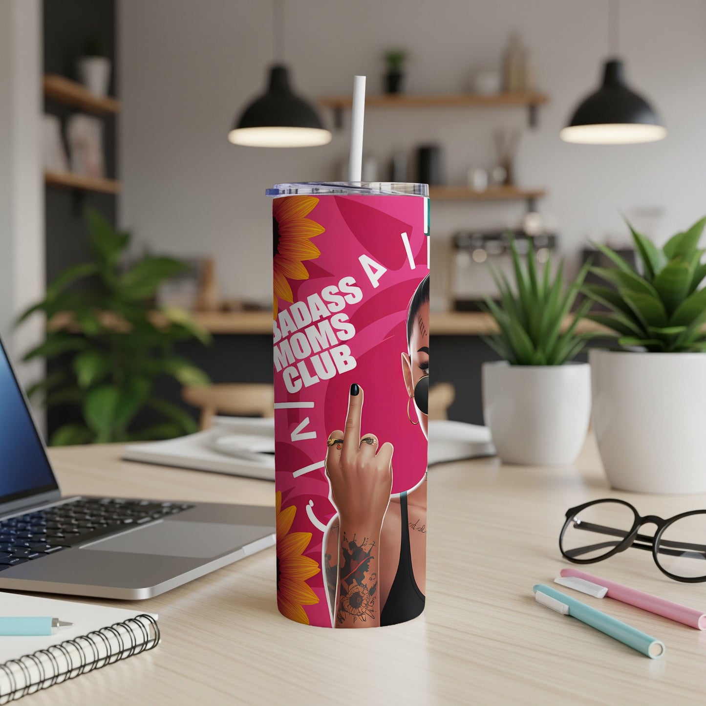 Pink tumbler with "BADASS MOMS CLUB" text, sunflower graphics, and woman's hand giving the middle finger.