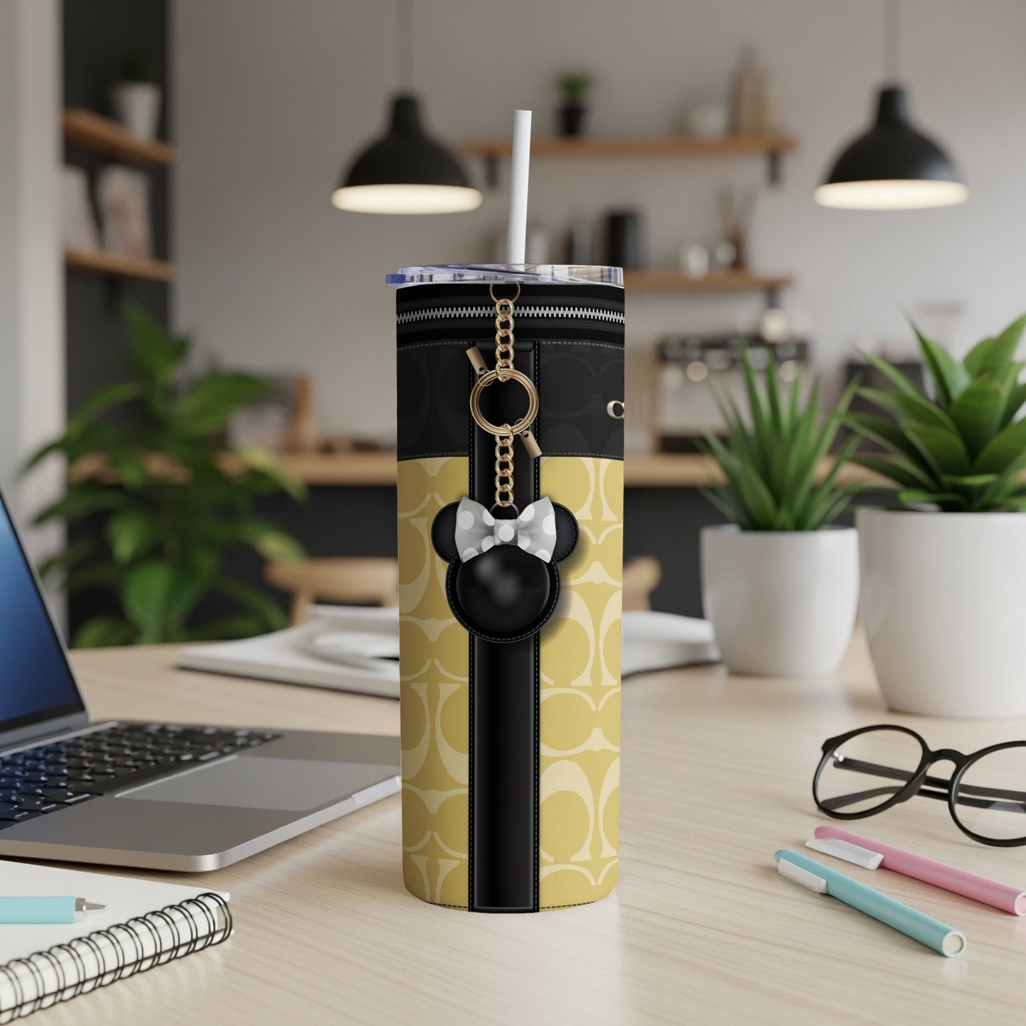 Travel tumbler with Minnie Mouse charm and iconic logo pattern.