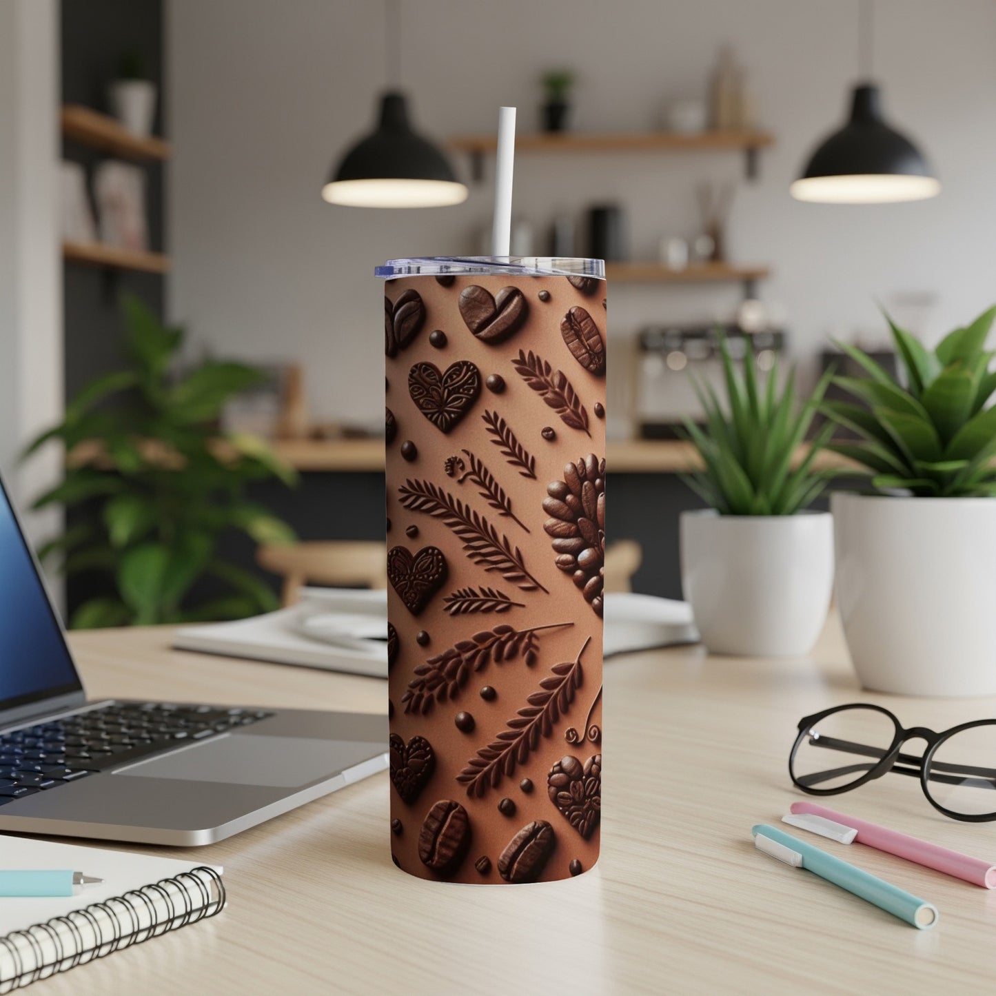 Brown tumbler with embossed coffee beans and leaves, with a straw.