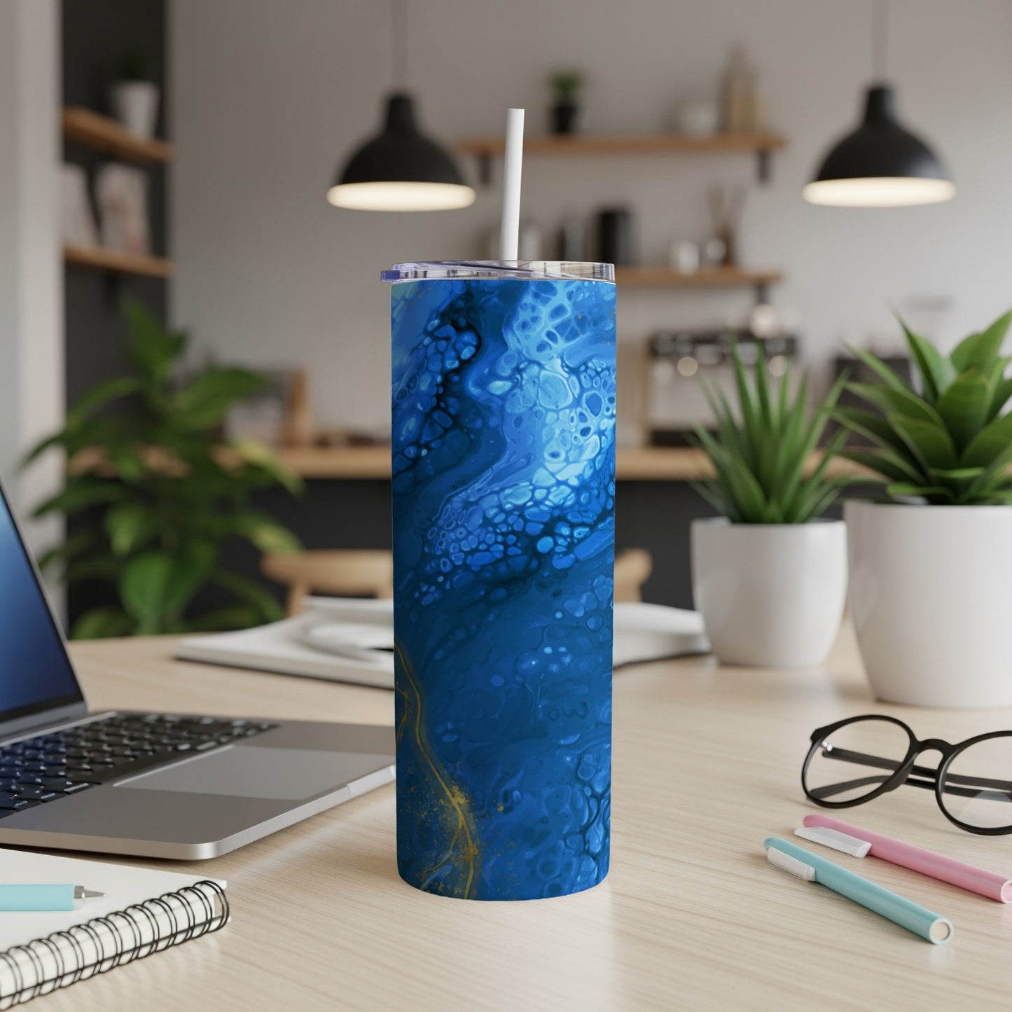 Tumbler with blue and gold abstract fluid art pattern and white straw.