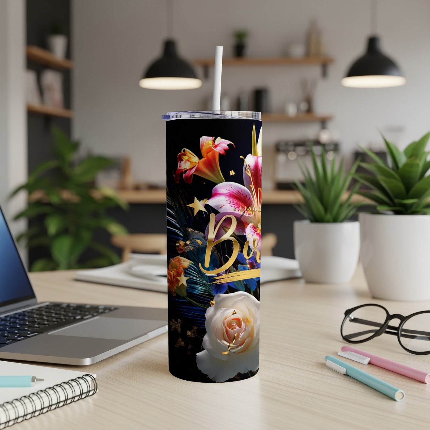 Black tumbler with floral design and "Bbie" text, on desk.