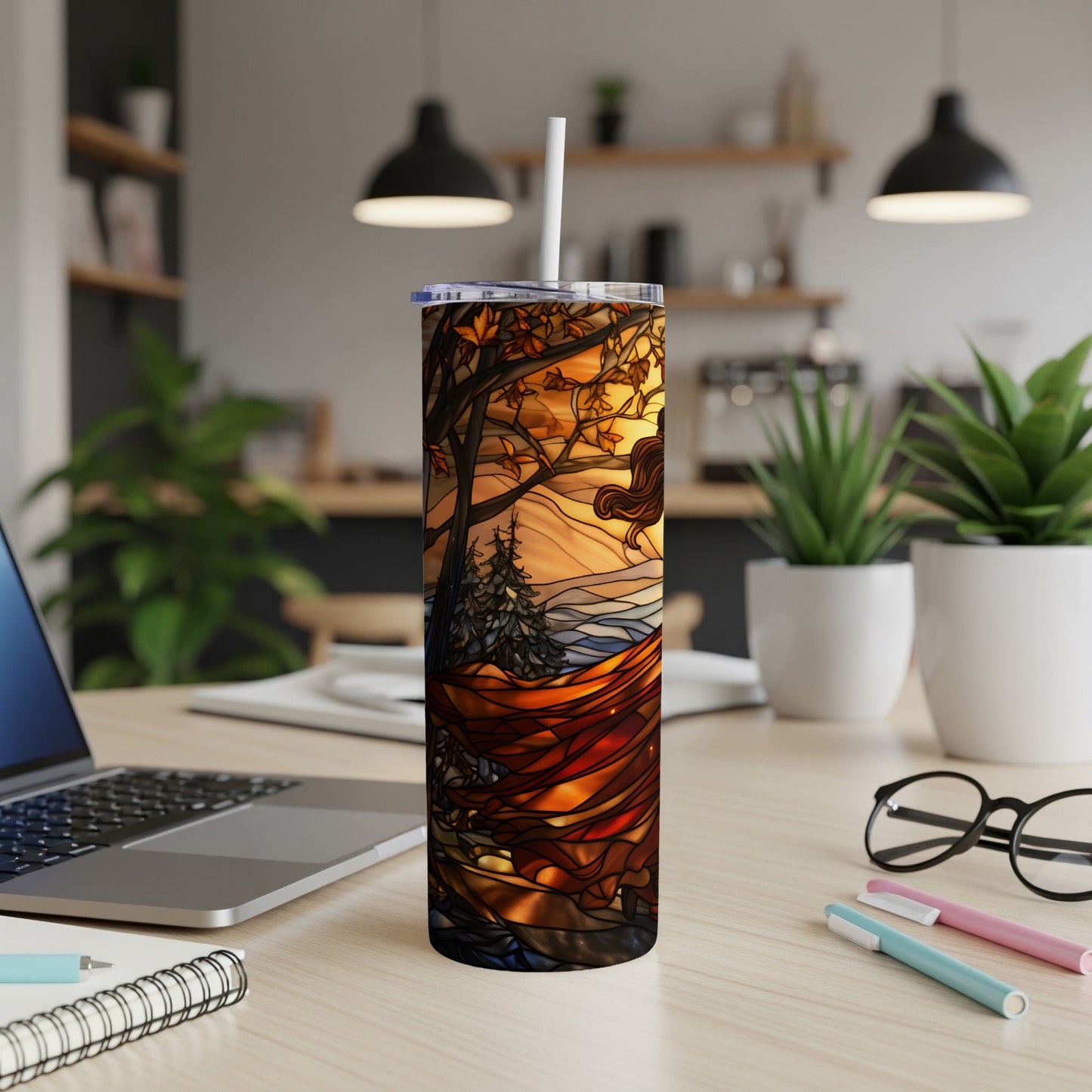 Stained glass tumbler with autumnal trees, mountains, and a woman's profile.