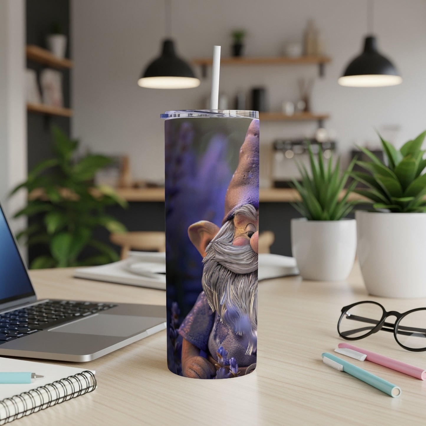 Tall tumbler with a cartoon gnome design and a straw, on a desk.
