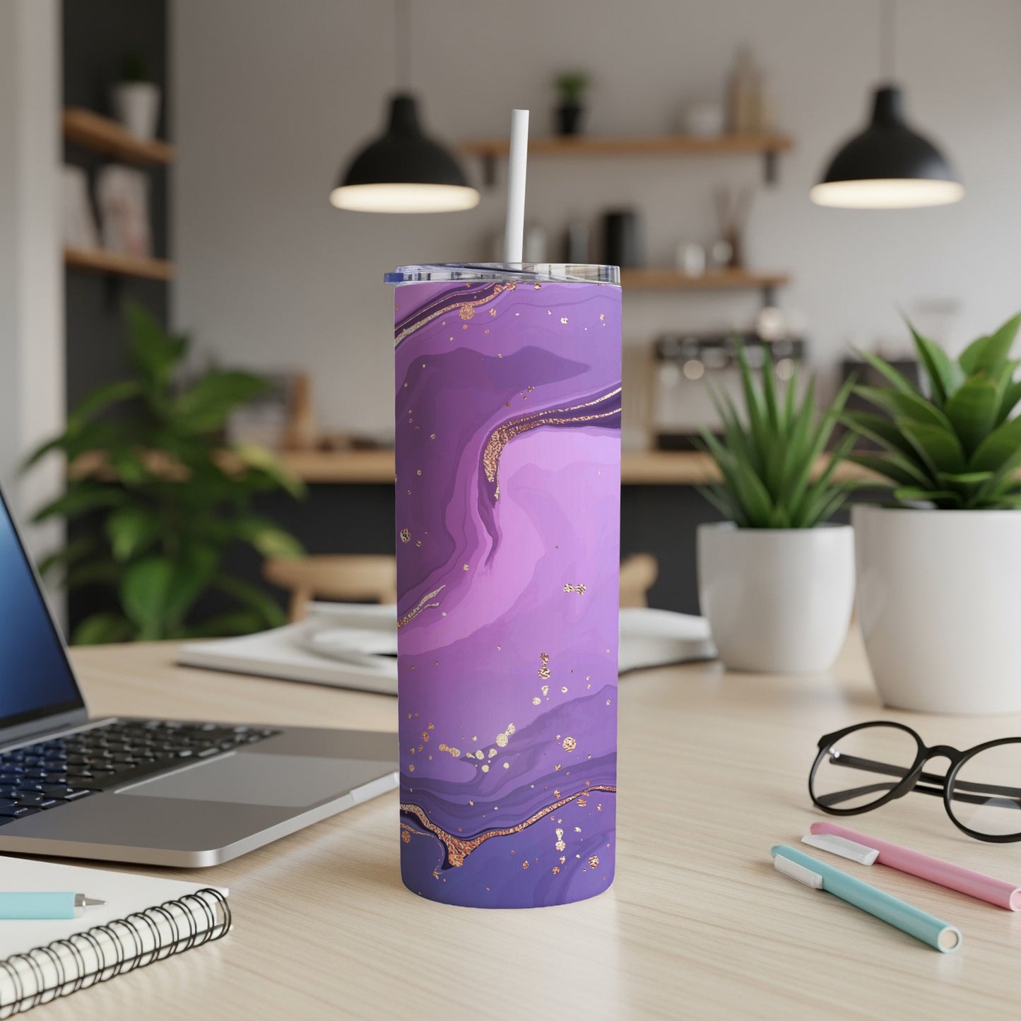 Purple marbled tumbler with gold flecks and white straw on a desk.