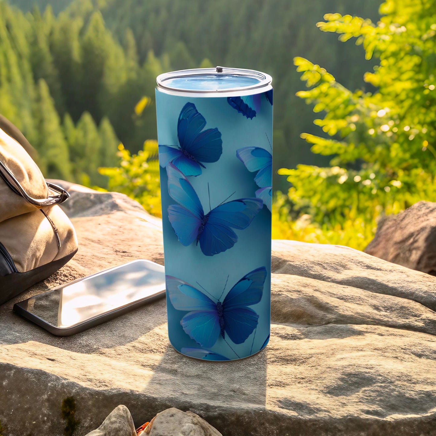 Blue butterfly pattern on a blue tumbler with phone and backpack.