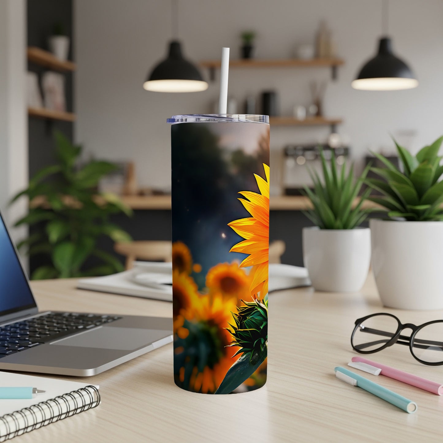 Sunflower design on a white tumbler with a straw, on a desk.