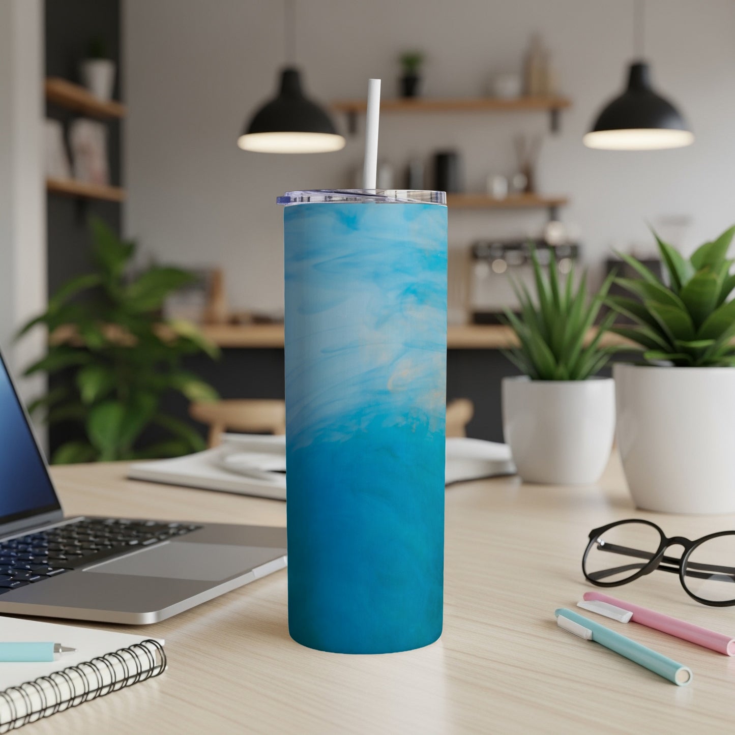 Blue abstract watercolor pattern on a stainless steel tumbler with white lid and straw.