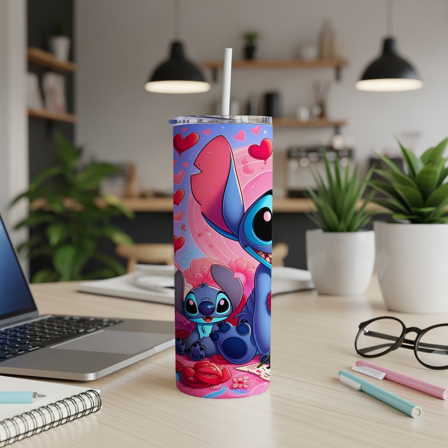 Stitch with hearts on a pink tumbler, on a desk with a laptop.