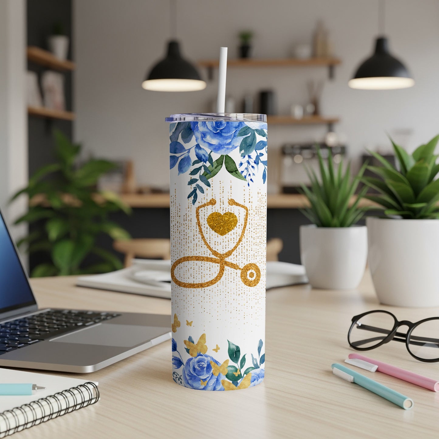 White tumbler with blue floral and gold butterfly design, stethoscope.