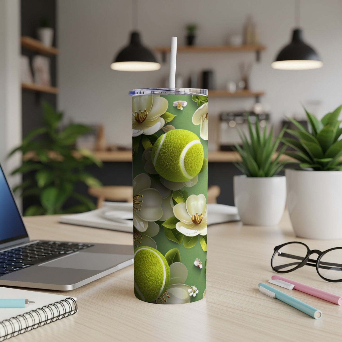 Green tumbler with white flowers and tennis balls.