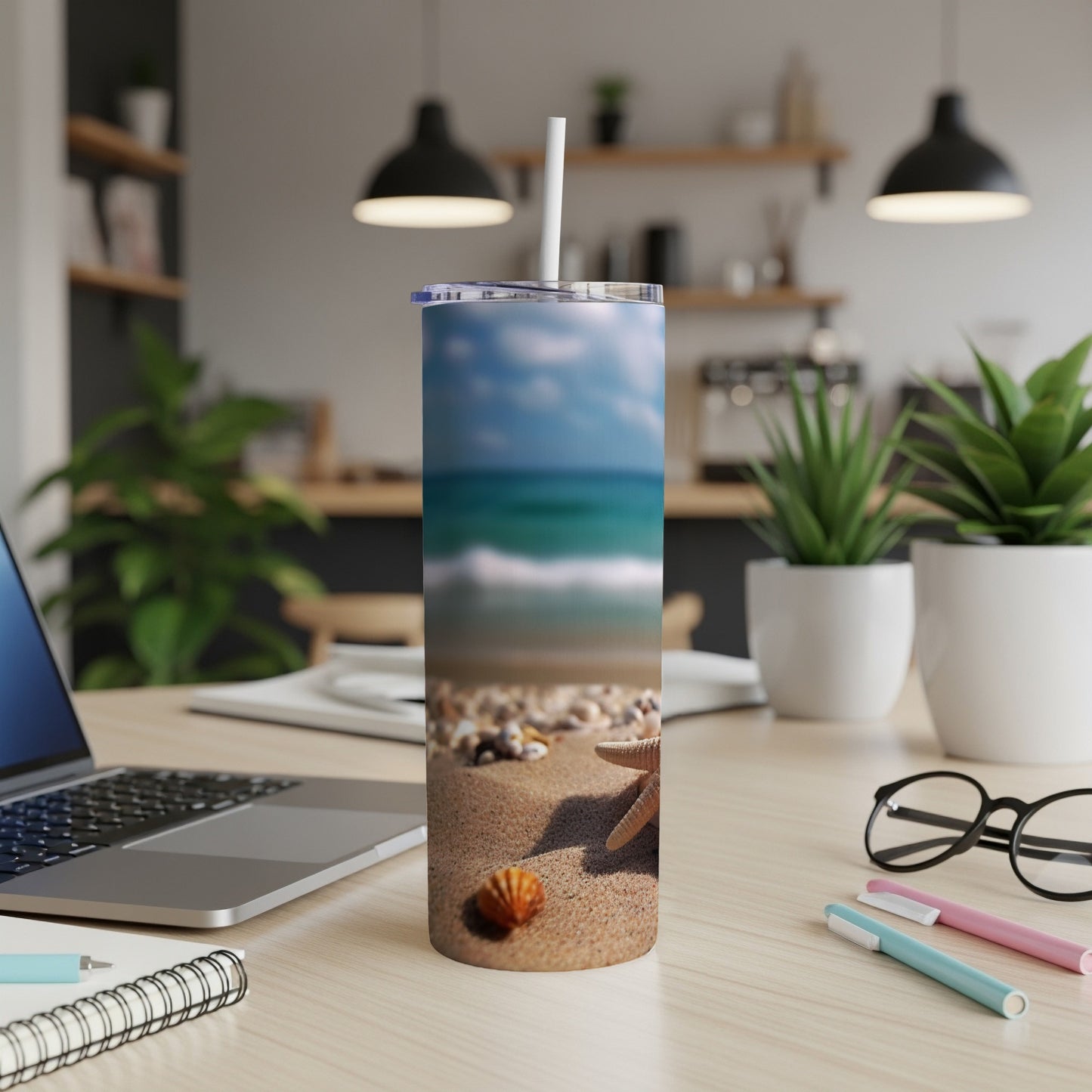 Beach scene tumbler with starfish and seashells on a table.