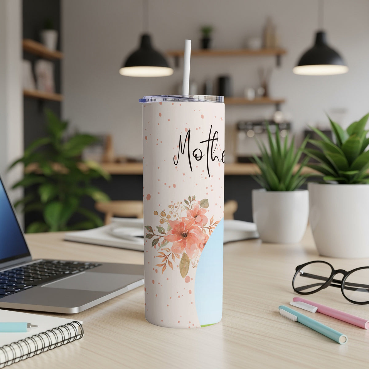 Skinny tumbler with "Mother" text and floral design on a desk.