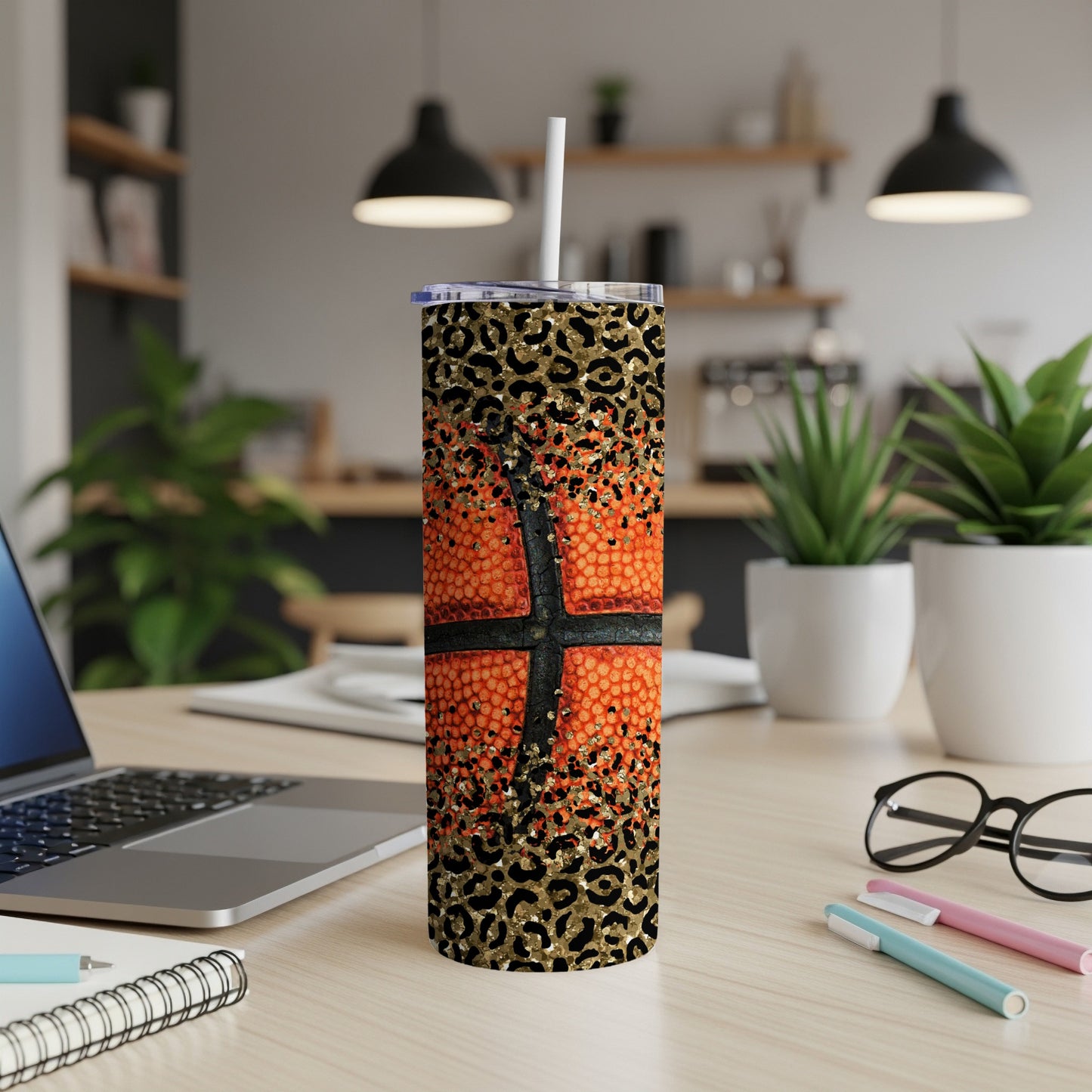Basketball tumbler with leopard print and straw on a desk.