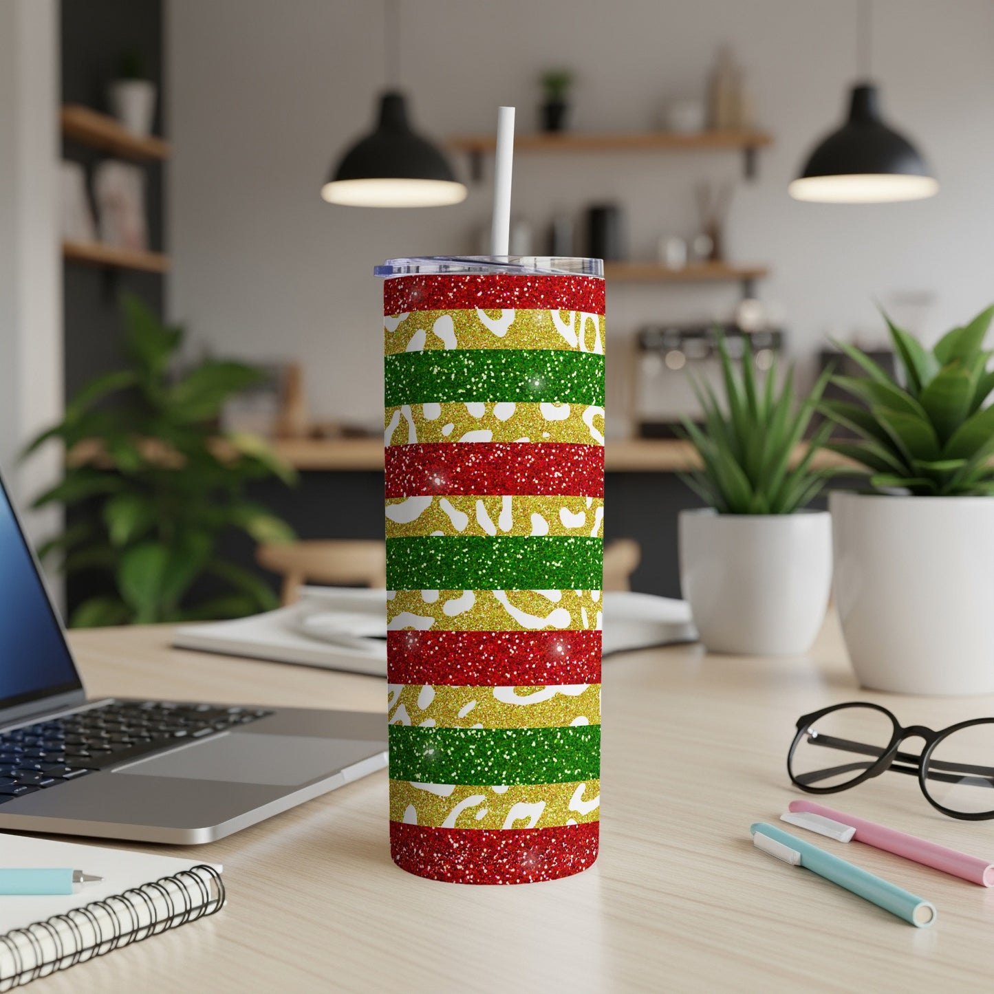 Glittery red, green, and gold striped tumbler with a white straw.