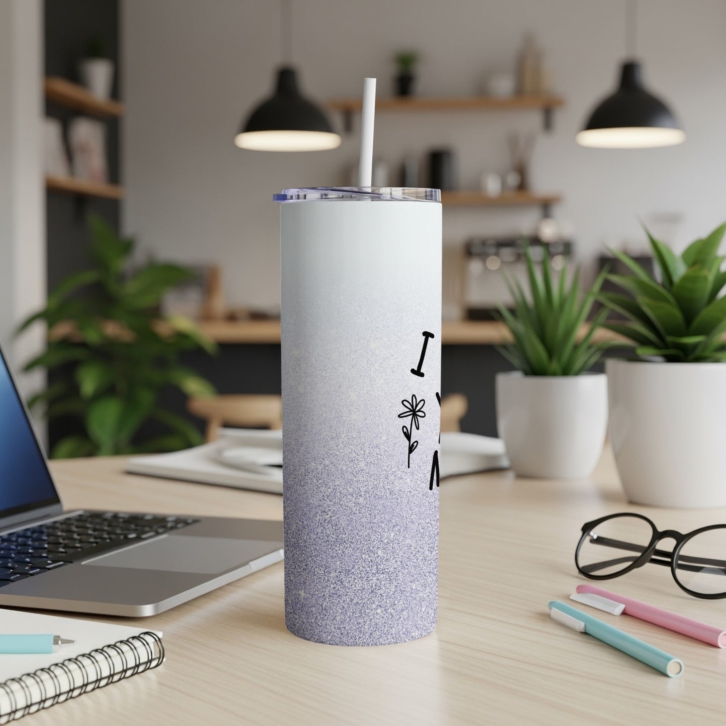 White and purple glitter tumbler with "I love my mom" text on desk.