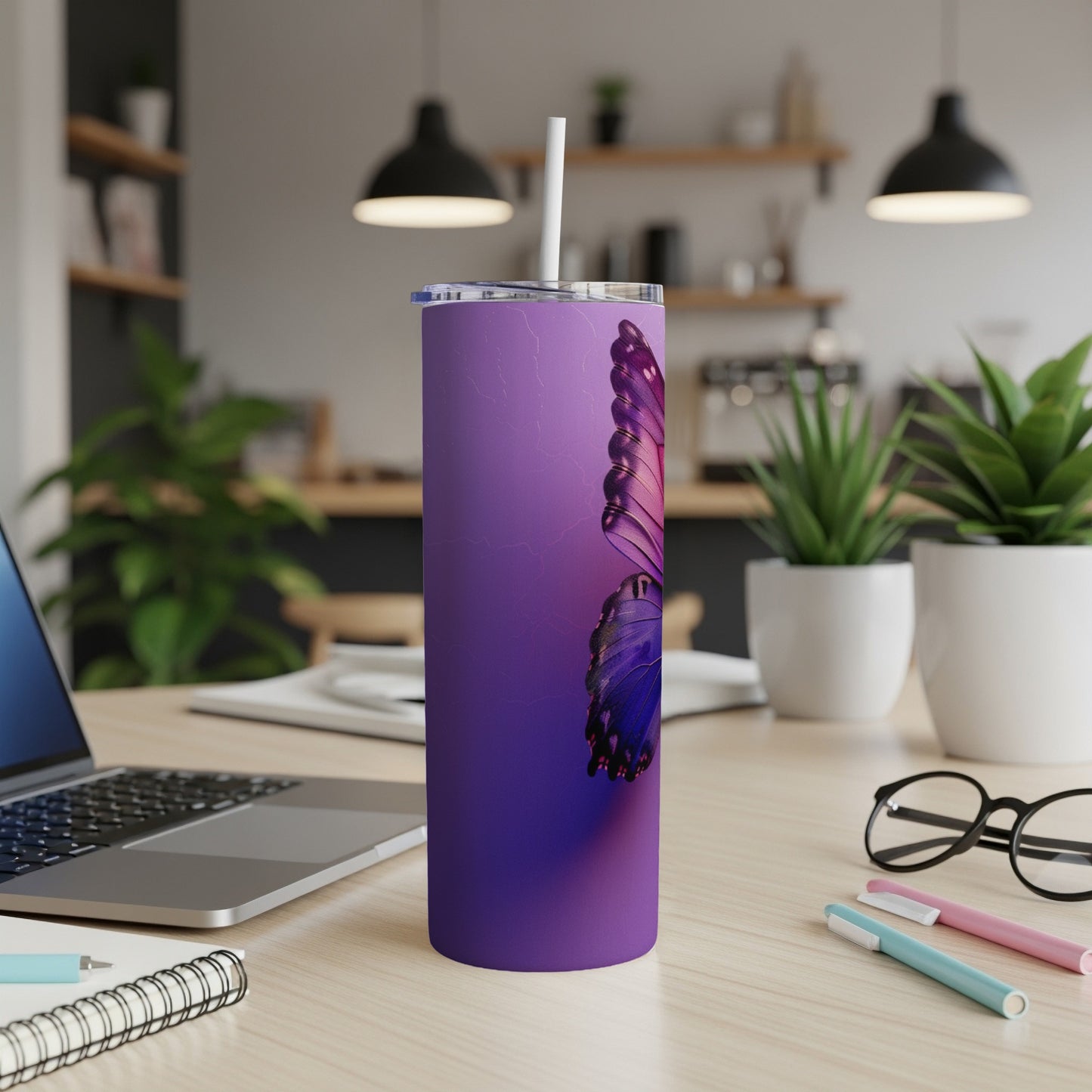Purple tumbler with a detailed butterfly design on a desk.