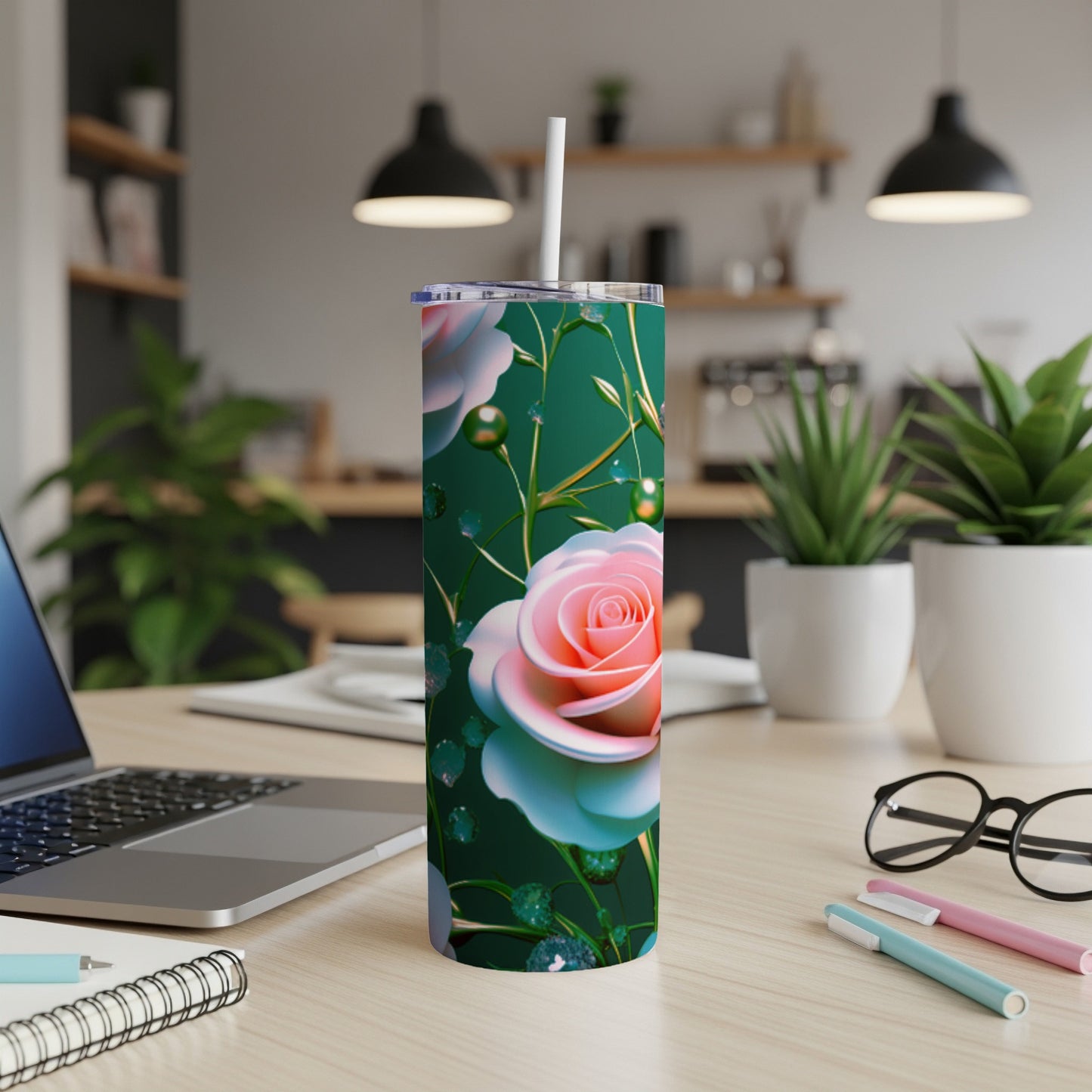 Pink rose design on a green tumbler with white straw, resting on a desk.