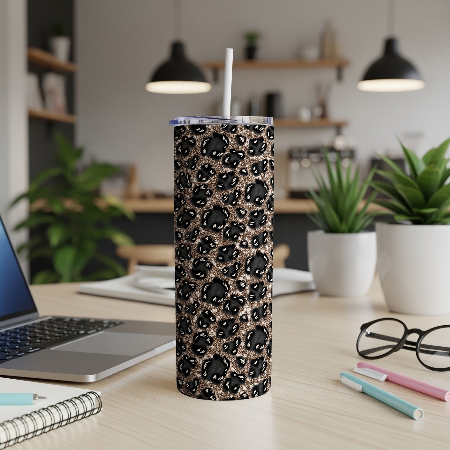 Black leopard print tumbler with white straw on a desk.