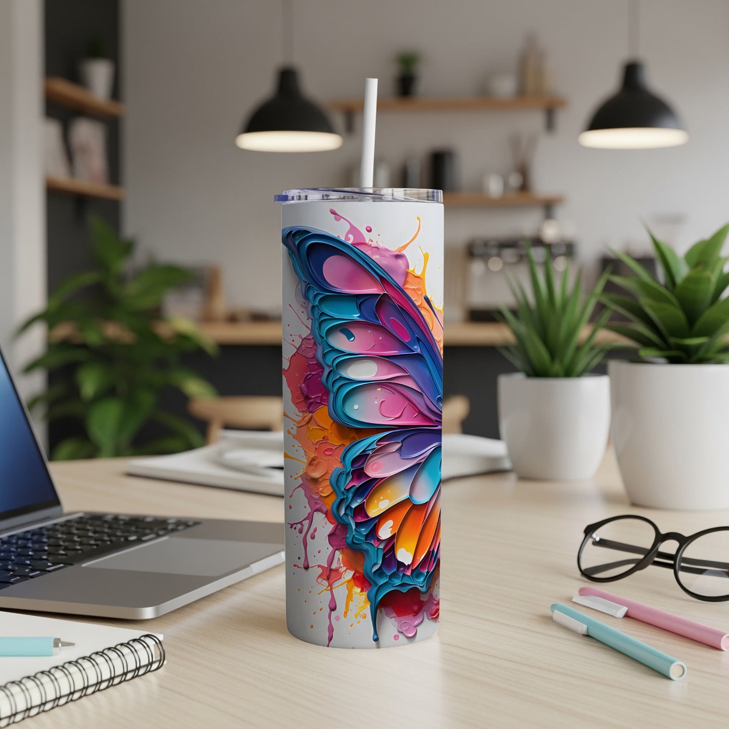 Tumbler featuring a colorful butterfly wing design with paint splatters.