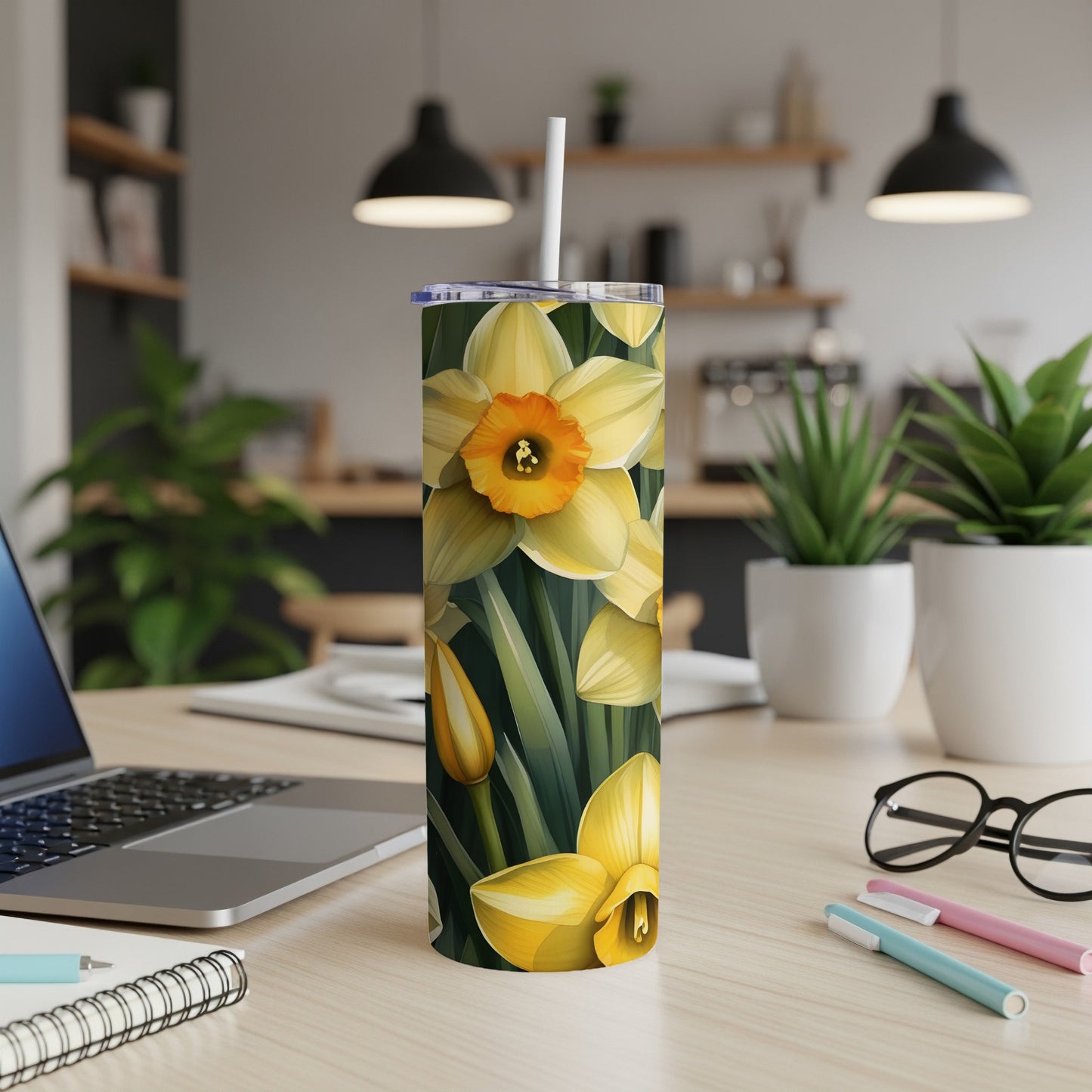 Yellow daffodils with green leaves pattern on a skinny tumbler with a white straw.