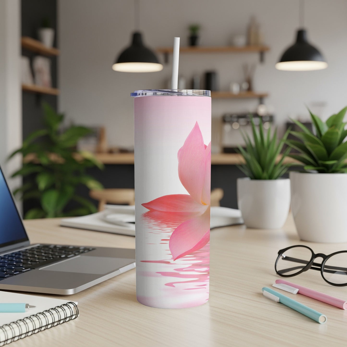 Pink lotus flower reflected in water on a white tumbler with straw.