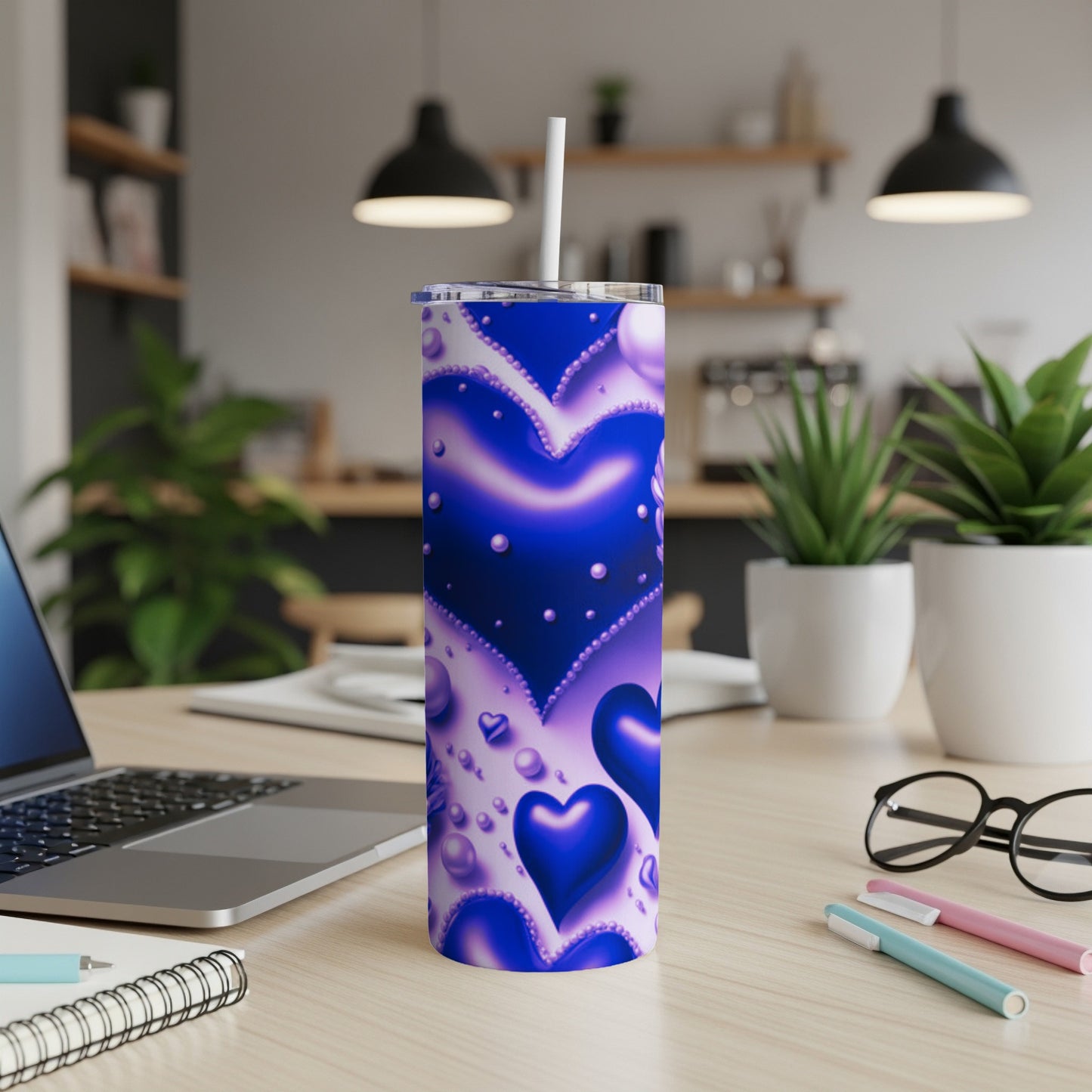 Blue glittery heart tumbler with straw on desk.