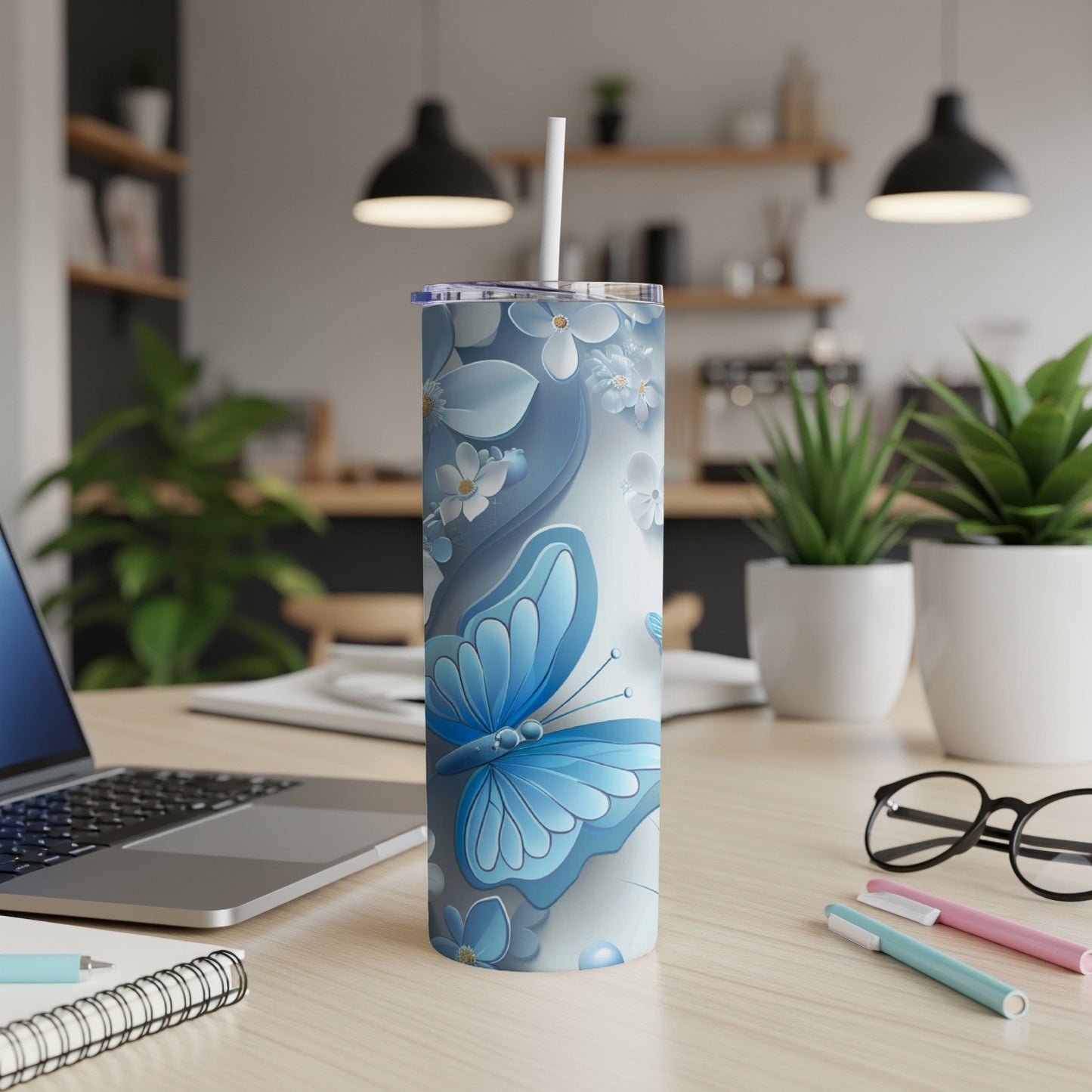 Blue butterfly and floral pattern on a white skinny tumbler with a straw.