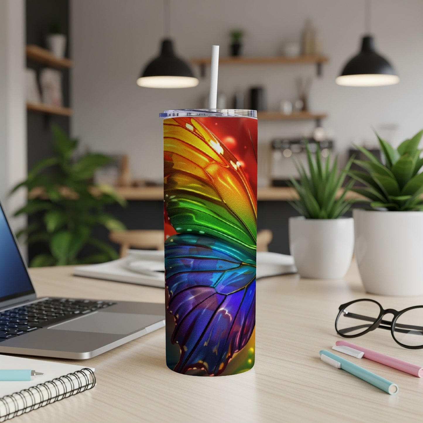 Rainbow butterfly wing design on a white tumbler with a straw.