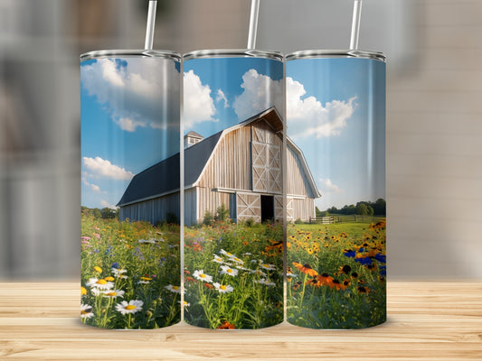 Barn with wildflowers under a blue sky, displayed on a wooden surface.