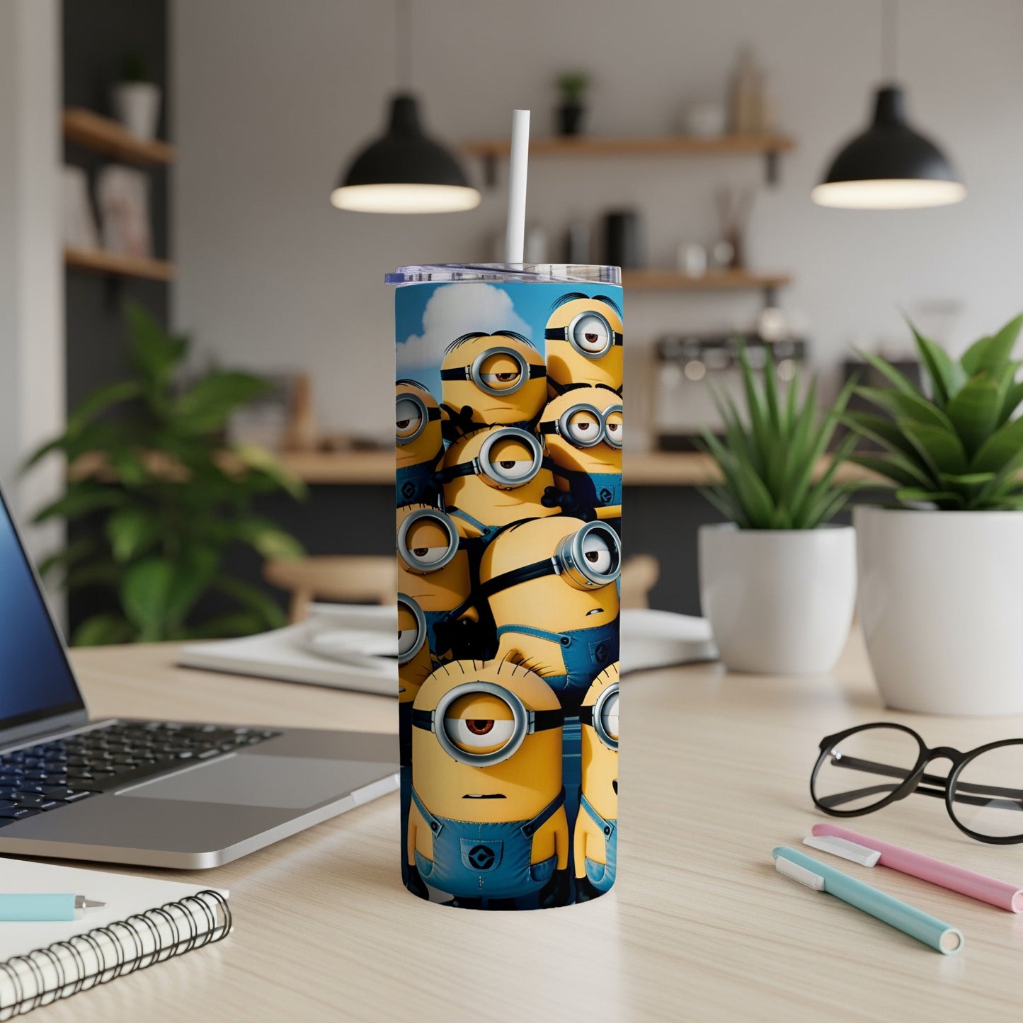Minions characters on a blue tumbler with a straw, on a desk.