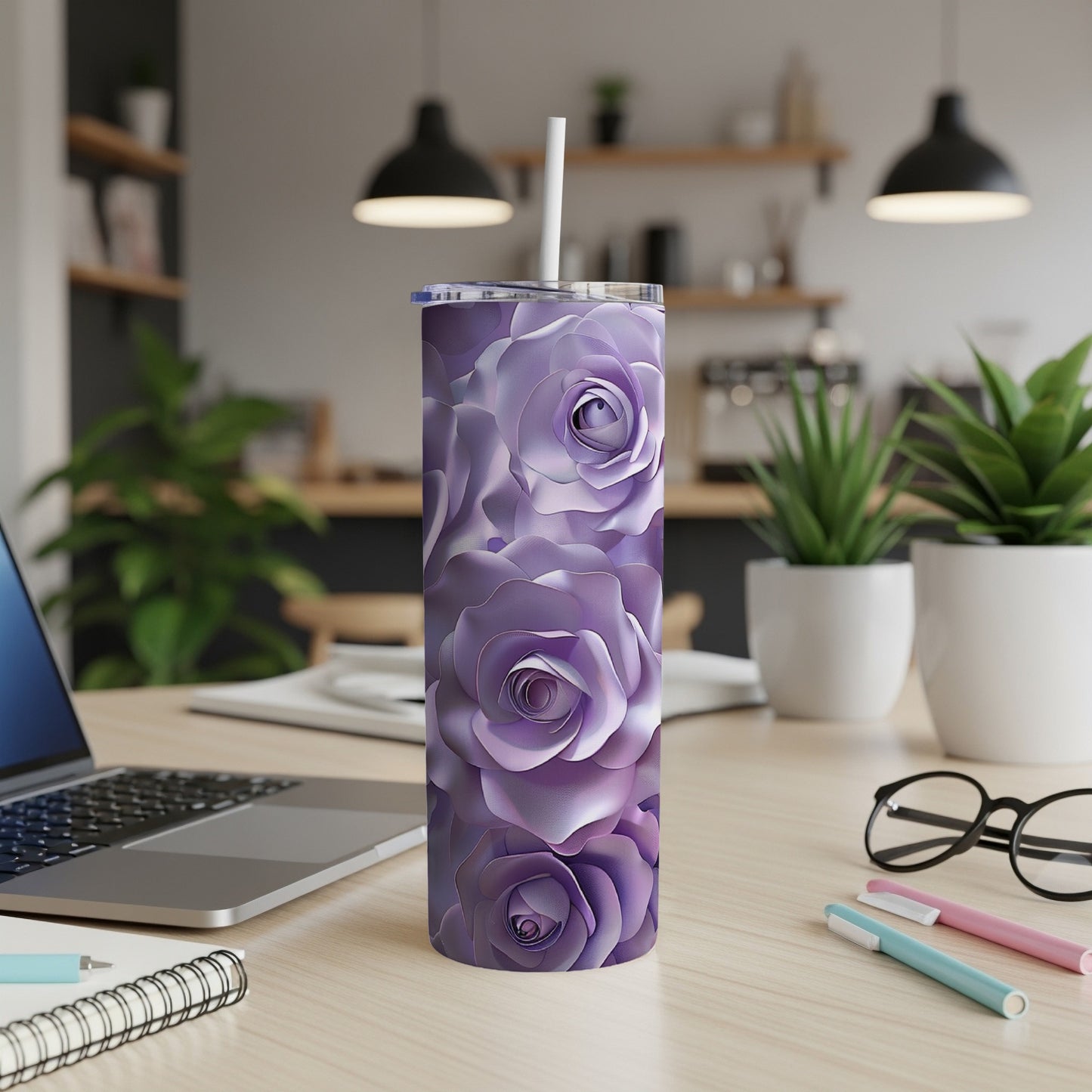 Purple rose patterned tumbler with straw on desk.