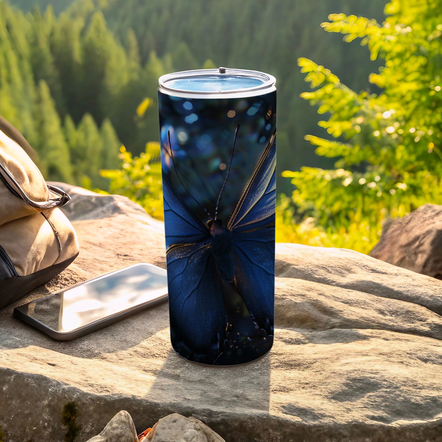 Blue butterfly design on a stainless steel tumbler with forest background.
