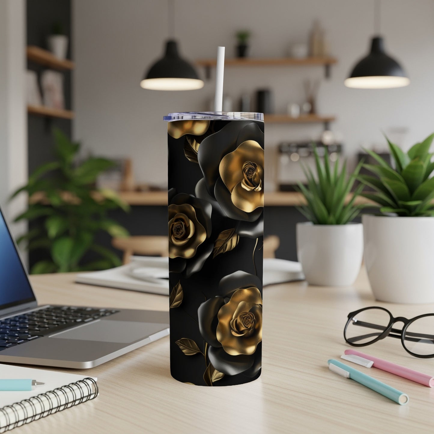 Black tumbler with gold rose pattern, white straw, on a desk.