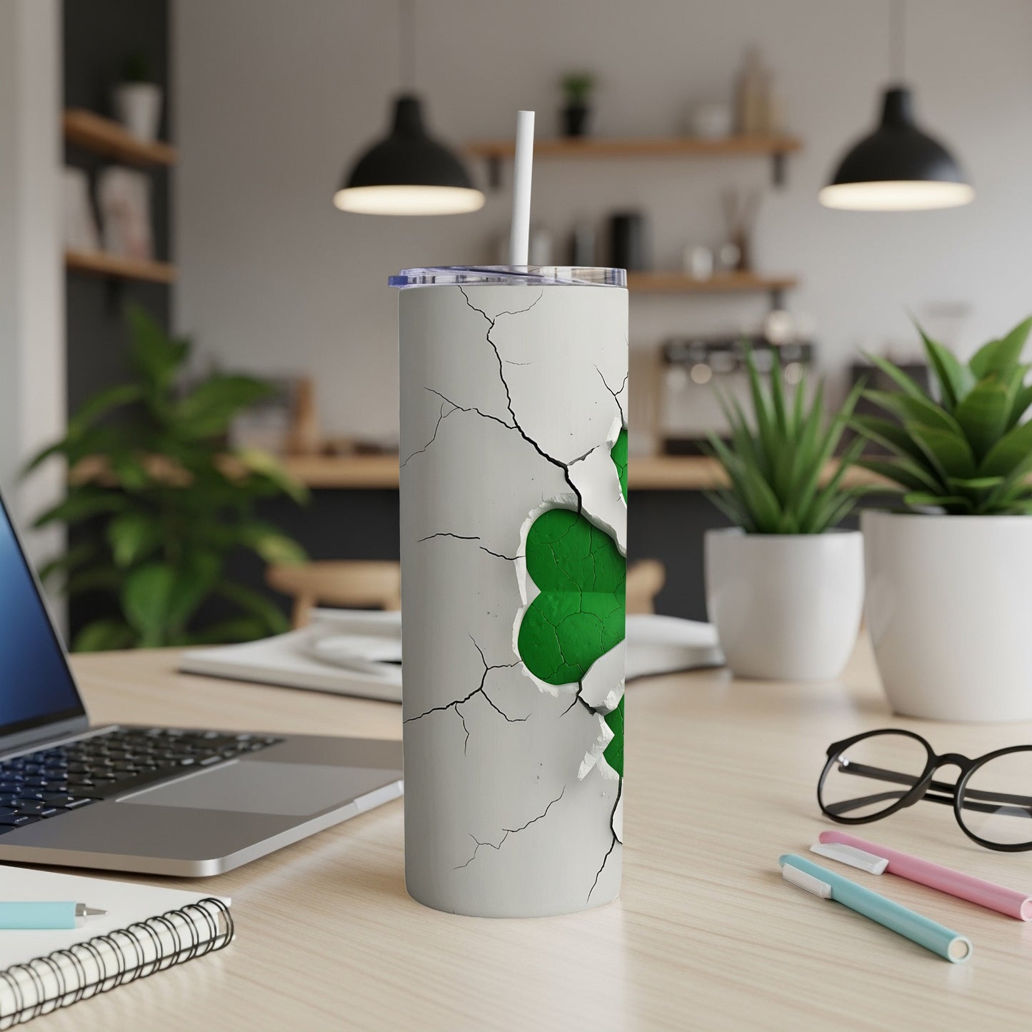 White tumbler with green shamrock design breaking through cracked surface.