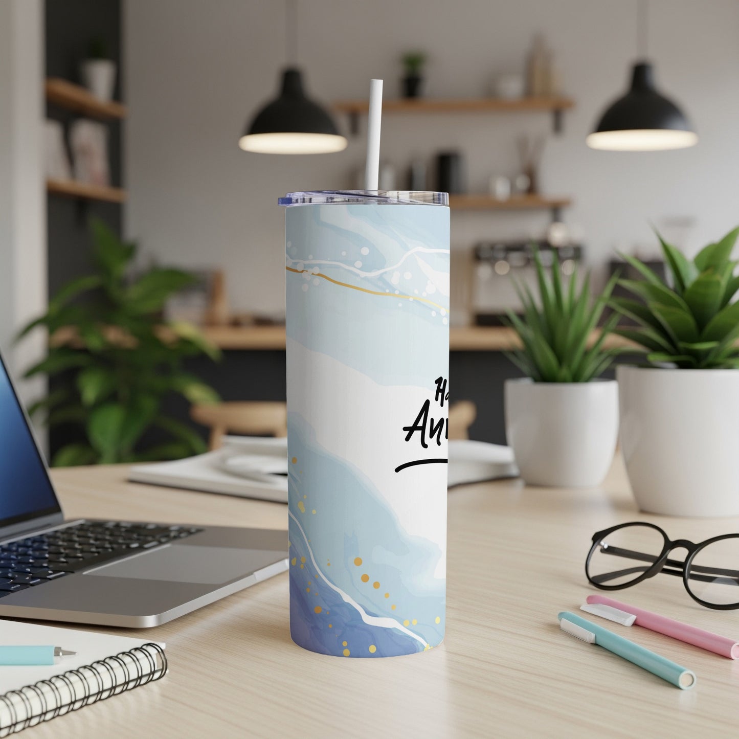 Blue and gold marbled tumbler with "Happy Anniversary" text, on a desk.
